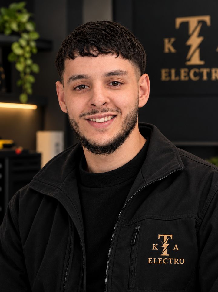 Tarik Abdellaoui, eigenaar van TKA Electro, in bedrijfskleding met het TKA Electro-logo.